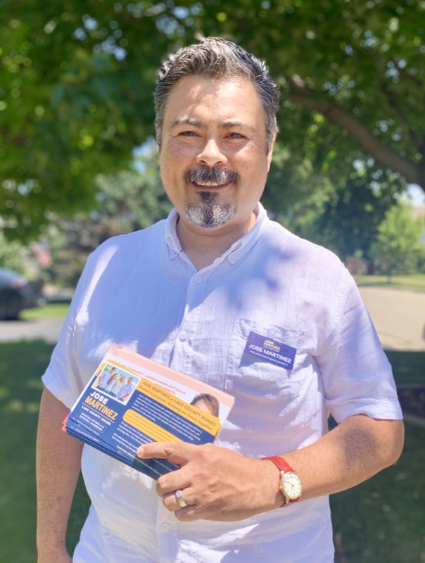 Jose Martinez holding campaign literature while canvassing the district