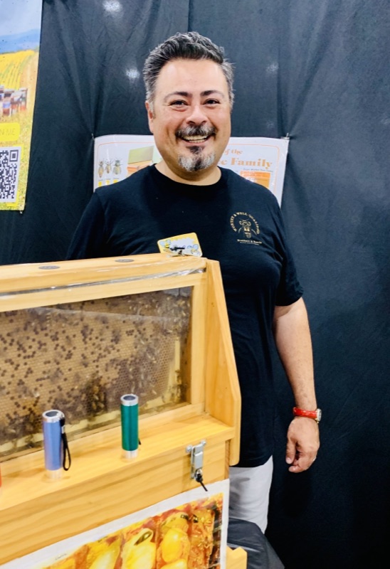 Jose Martinez volunteering at a beekeeping booth with an observation hive at the Lake County Fair