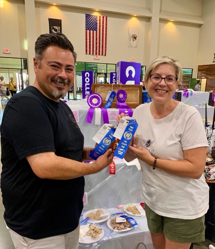 Jose Martinez holding first-place honey ribbons at the Lake County Fair